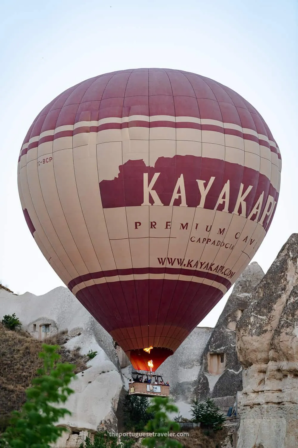 A hot air balloon passing near a fairy chimney in Cappadocia