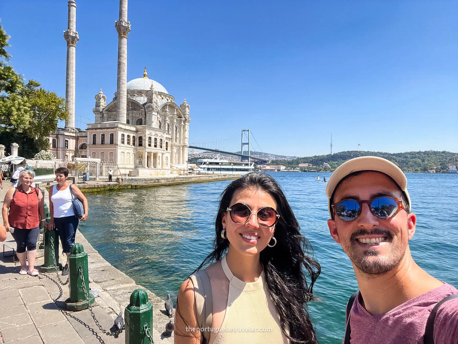 A selfie of two people in front of the Ortaköy Mosque and the Bosphorus Bridge in Istanbul