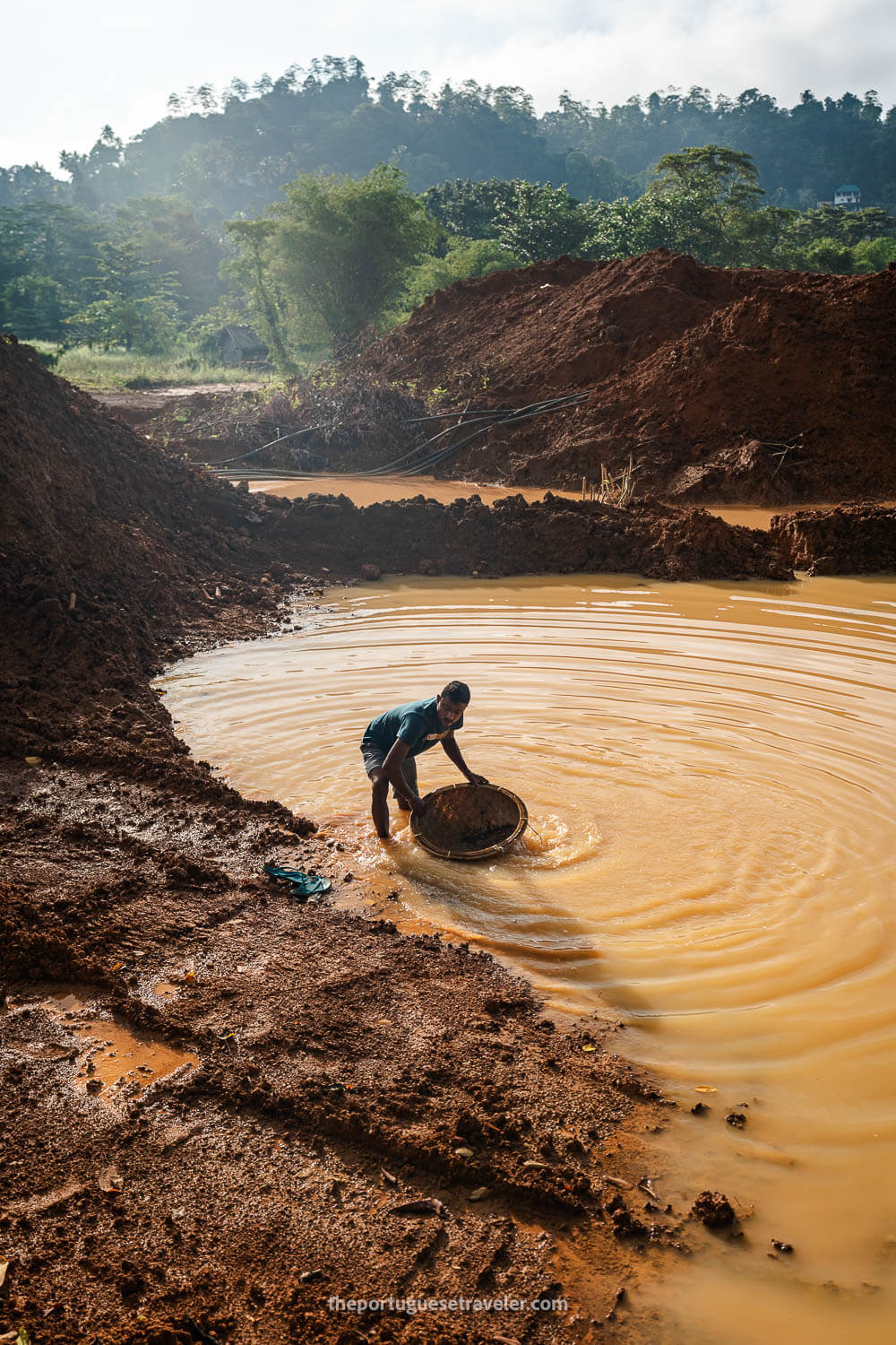 One of the miners filtering the gravel on the pond's bed