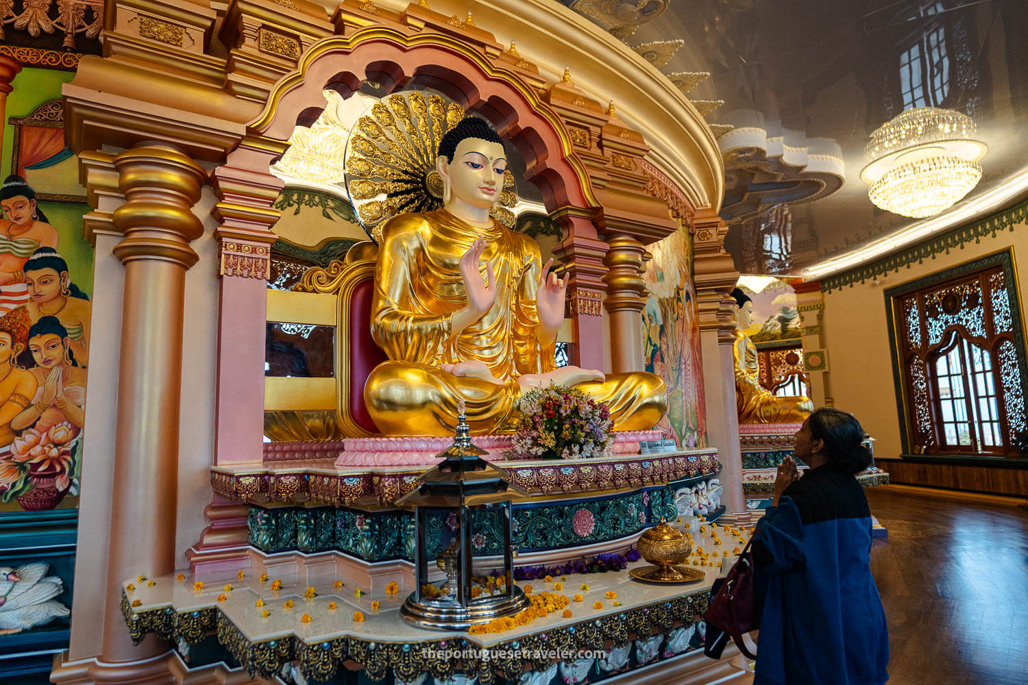 A devotee inside the temple praying to a Buddha statue