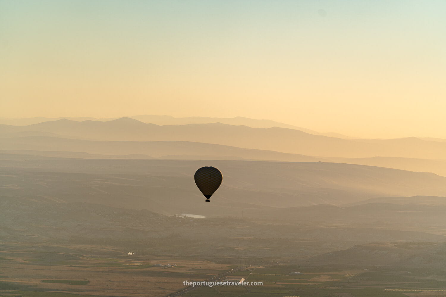 A hot air balloon's silhouette in Cappadocia at sunrise