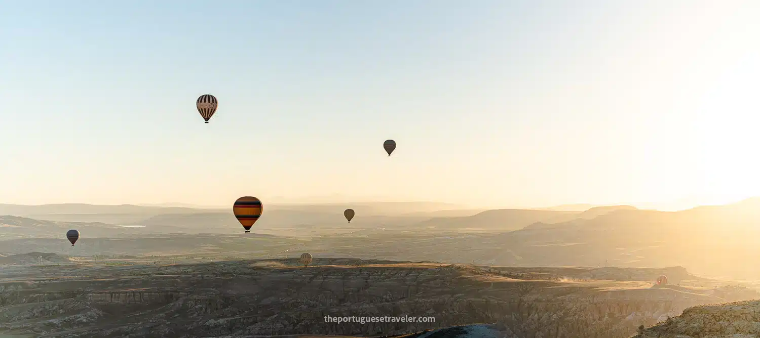 A panorama of the hot air balloons landing and floating at Sunset in Cappadocia